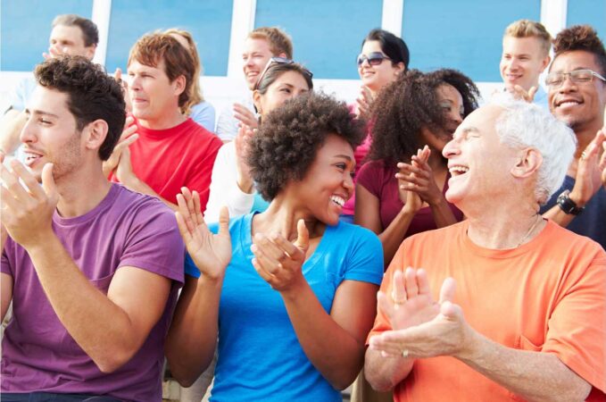 Adults with smiles on their faces clapping hands