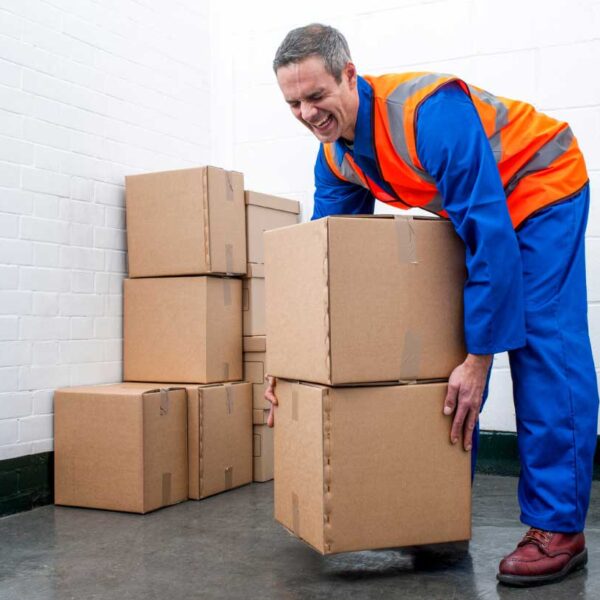 Man grimicing while picking up two cardboard boxes