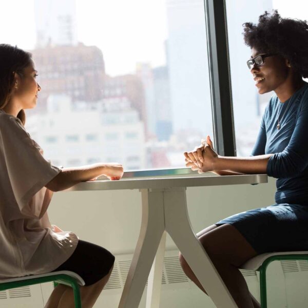 Two women sitting across from each other at a table